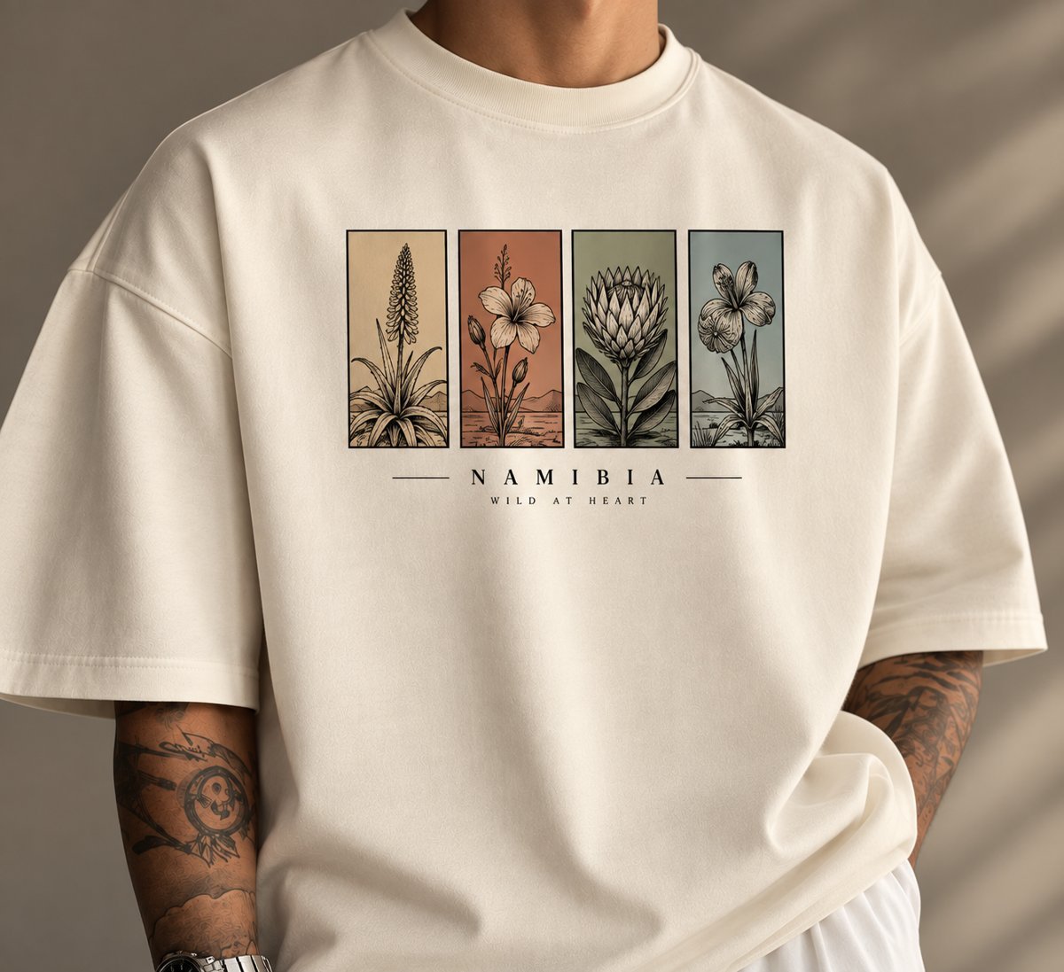Cream T-shirt printed with four Namibian plant illustrations and the words Namibia, Wild at Heart