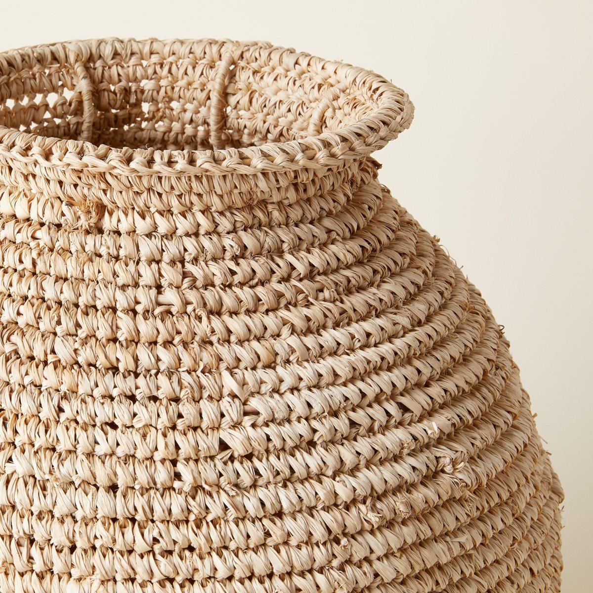 Close-up of a hand-woven natural fibre basket with a rolled rim